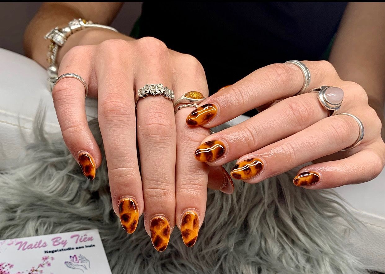 Amandelvormige nagels in schildpadprint, op een grijs vachtje
