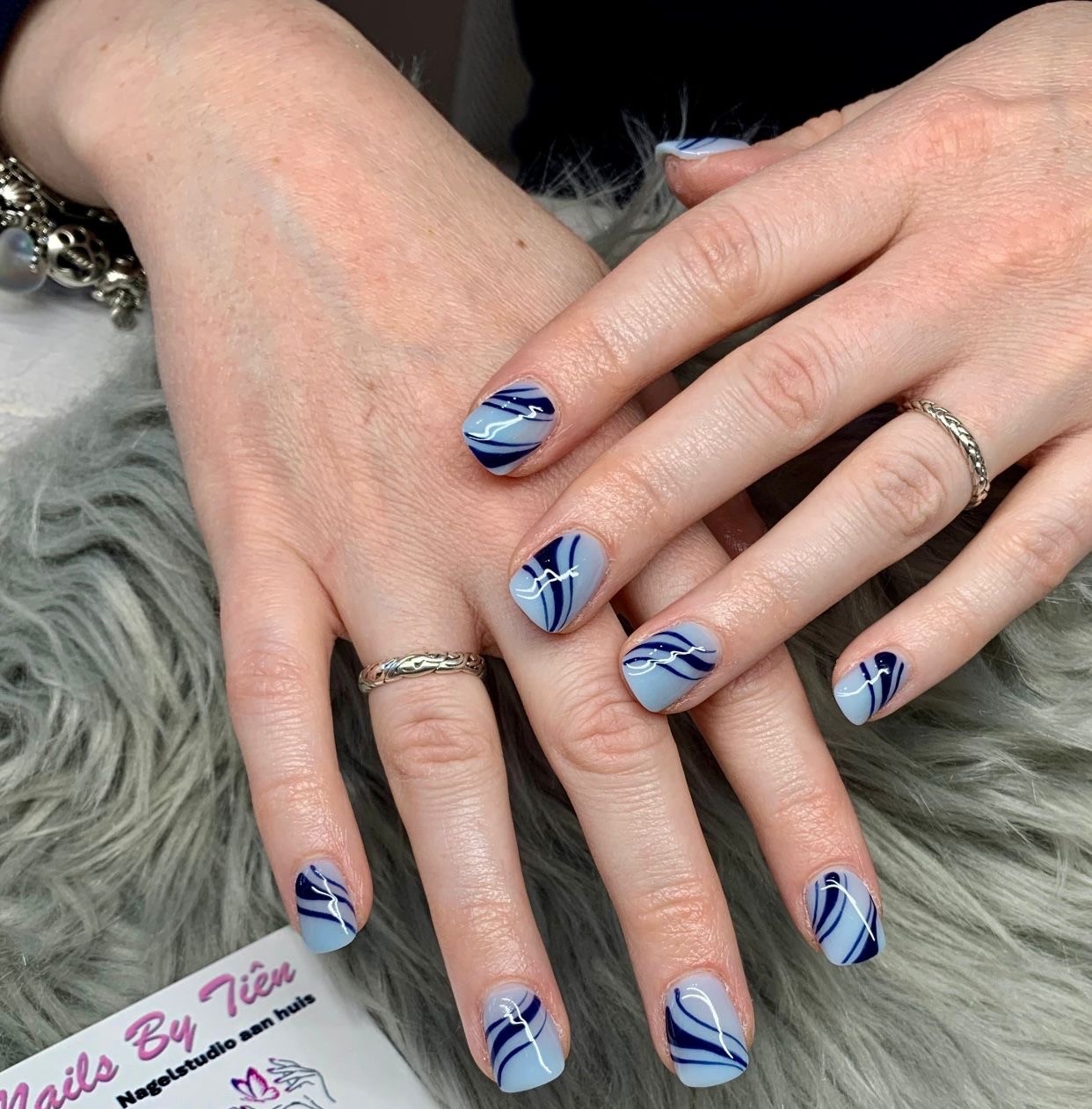 Korte nagels in lichtblauw met donkerblauwe marmerlijnen